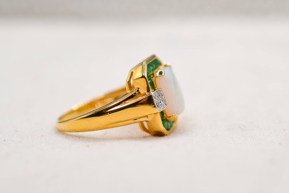 bague-en-or-jaune-ornee-d-une-opale-rectangulaire-entouree-d-emeraudes-rondes-en-serti-rail-et-de-diamants-ronds-bague-vintage