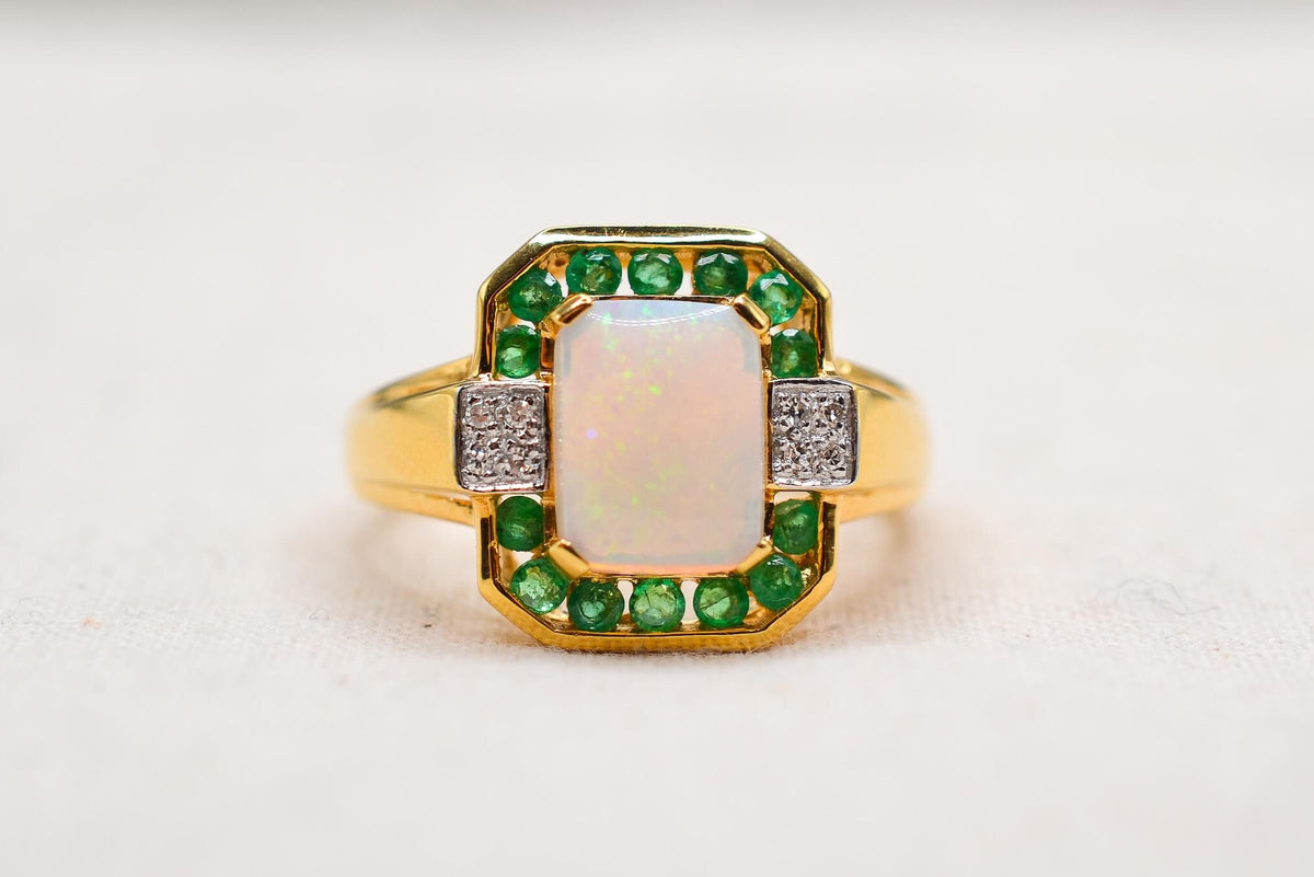 bague-en-or-jaune-ornee-d-une-opale-rectangulaire-entouree-d-emeraudes-rondes-en-serti-rail-et-de-diamants-ronds-bague-ancienne