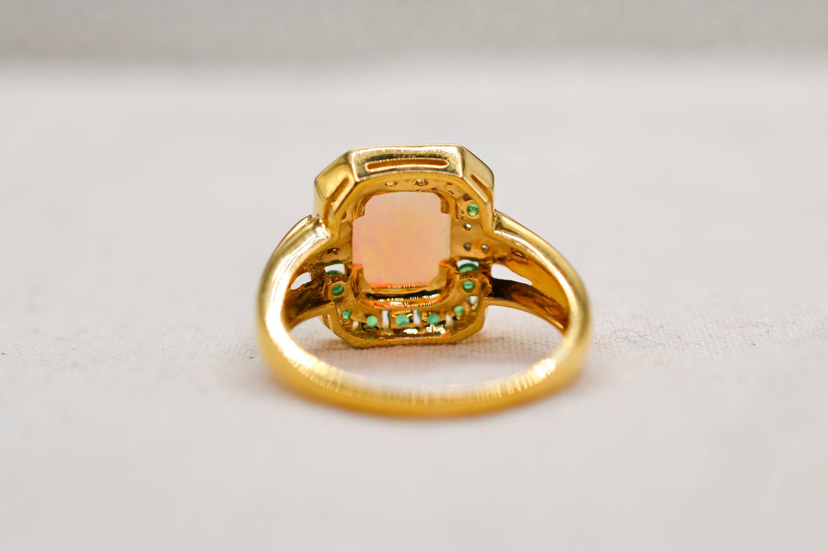 bague-en-or-jaune-ornee-d-une-opale-rectangulaire-entouree-d-emeraudes-rondes-en-serti-rail-et-de-diamants-ronds-bague-femme
