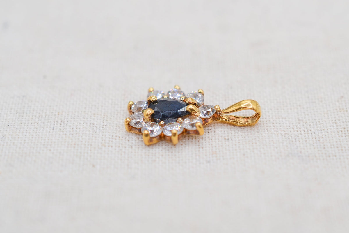 pendentif-marguerite-en-or-jaune-18-carats-orne-en son-centre-d-un-saphir-taille-en-poire-dans-un-entourage-d-oxydes-pendentif-femme