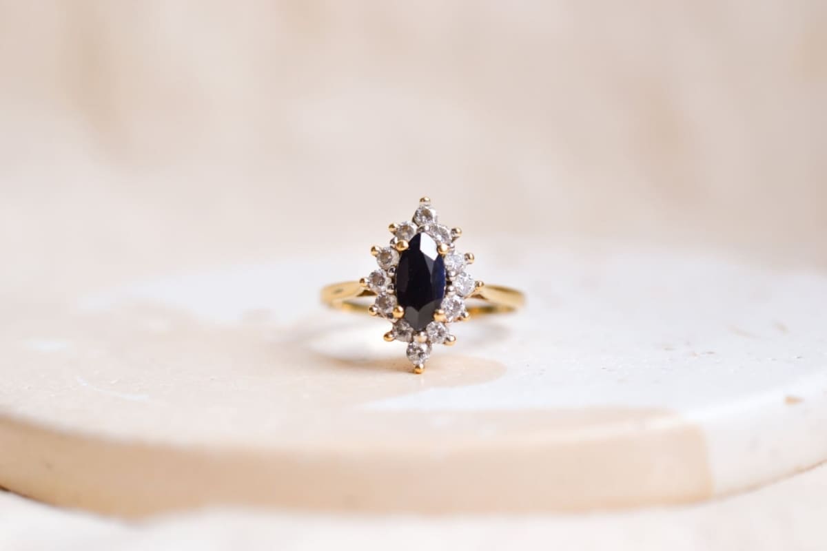 Bague Marquise en Or jaune 18 carats centrée d'un Saphir serti griffes entouré d'Oxydes