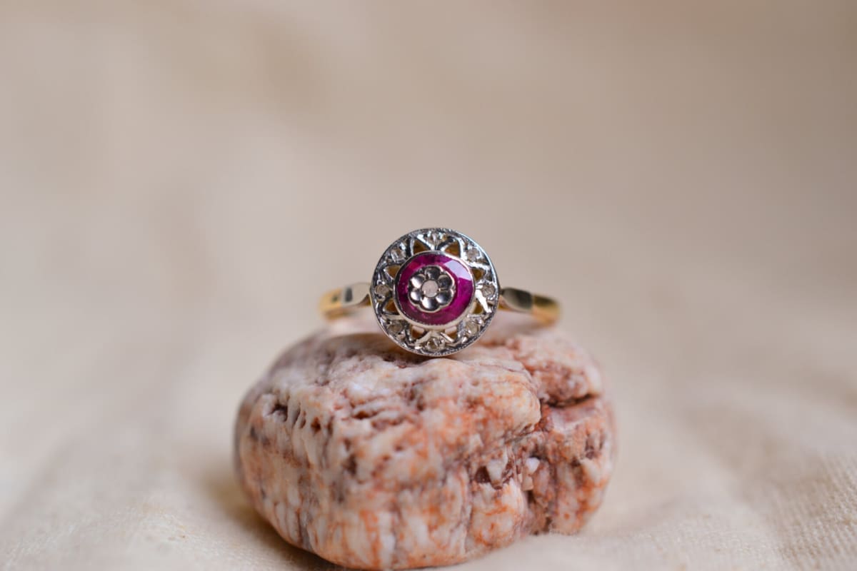 Bague circulaire Art Déco en Or jaune et Or blanc 18 carats sertie de Rubis et de Diamants dans un décor de triangles ajourés