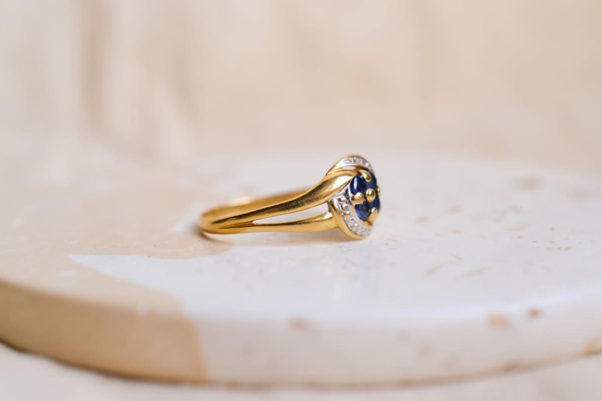 Bague en Or jaune et Or blanc 18 carats centrée de Saphirs en fleur sur une monture ajourée