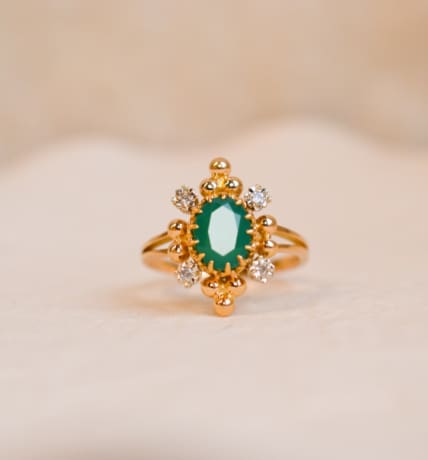 Bague Marguerite ancienne en Or jaune 18 carats centrée d'une Émeraude sertie griffes entourée de Diamants