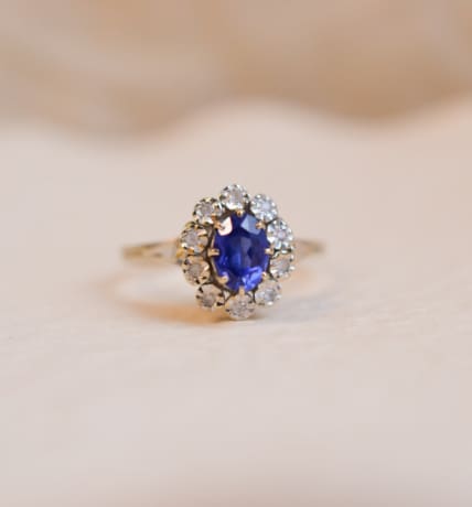 Bague Marguerite ancienne en Or blanc 18 carats centrée d'une pierre bleue entourée de pierres blanches