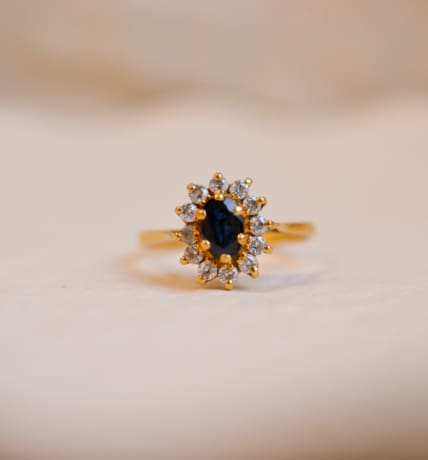 Bague Marguerite ancienne en Or jaune 18 carats centrée d'un Saphir entouré de pierres blanches