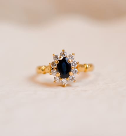 Bague Marguerite en Or jaune 18 carats centrée d'un Saphir entouré de pierres blanches