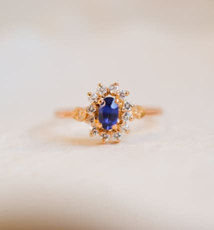 Bague Marguerite ancienne en Or jaune 18 carats centrée d'un Saphir de synthèse entouré d'Oxydes de zirconium