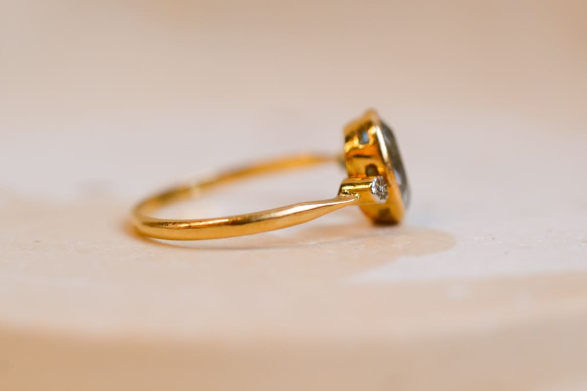 Bague Vintage en Or jaune 18 carats sertie clos d'une Aigue-Marine ponctuée de fleurs d'Or blanc