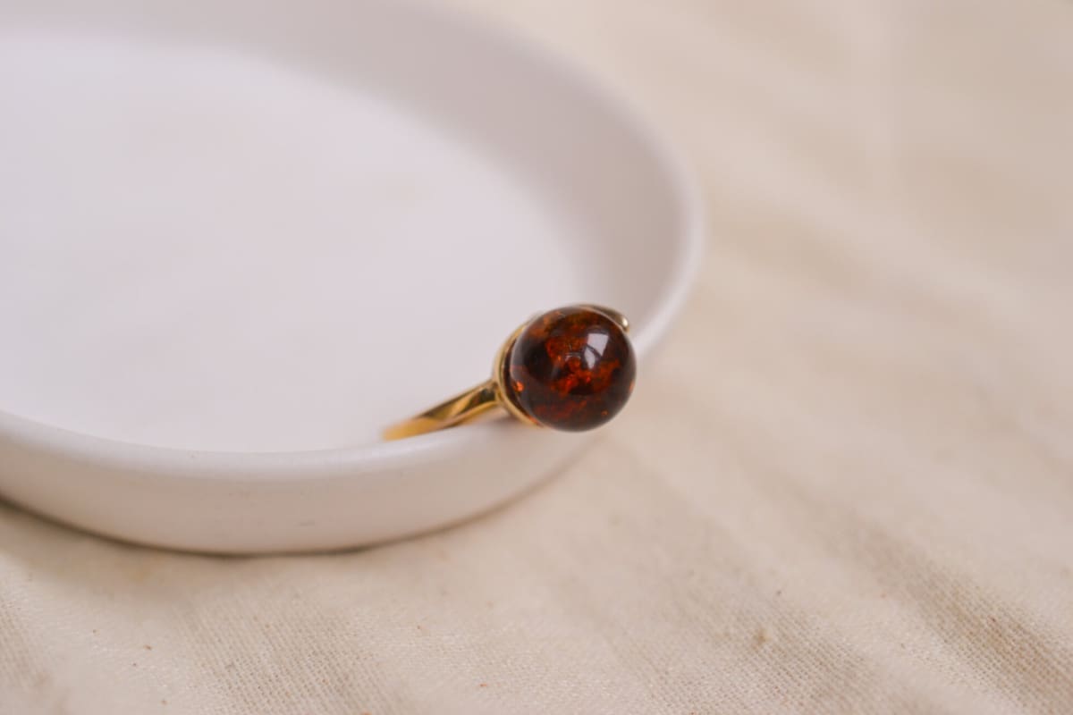 Bague en Or jaune 18 carats ornée d'une boule d'Ambre soutenu par une tige perforée