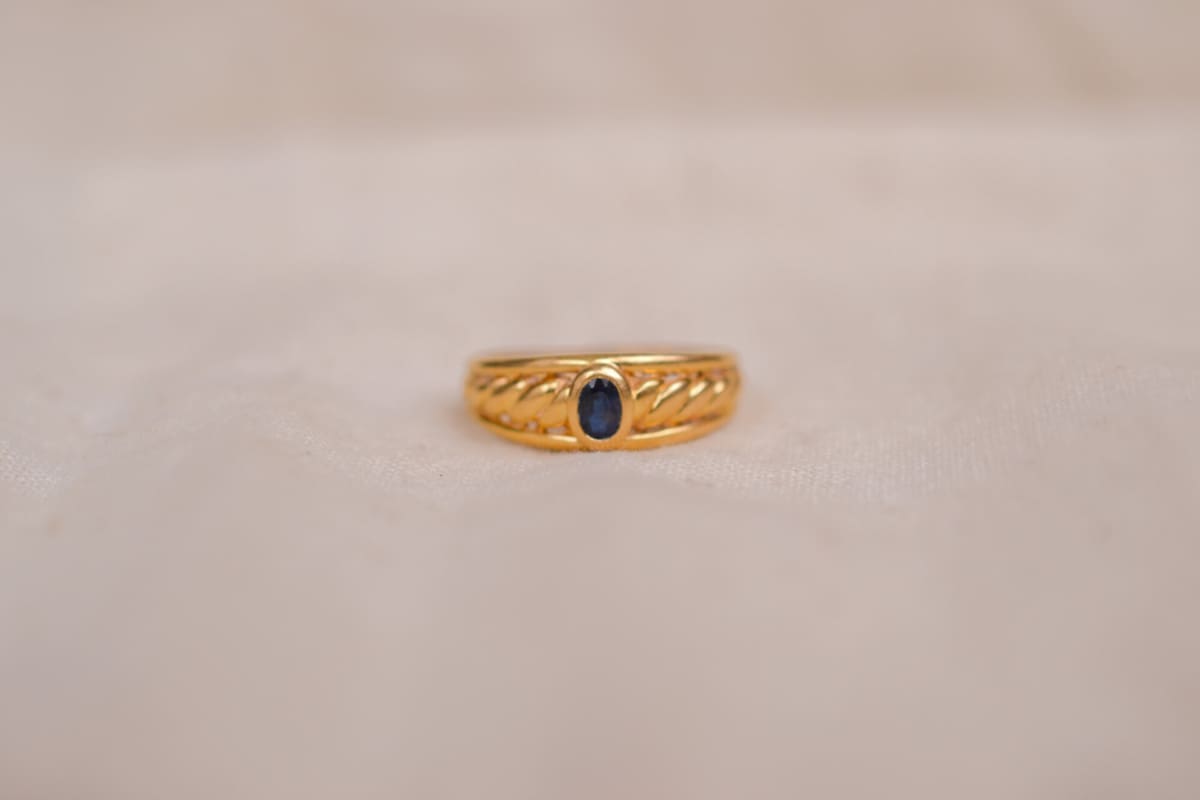Bague jonc torsadée en Or jaune 18 carats centrée d'un Saphir serti clos