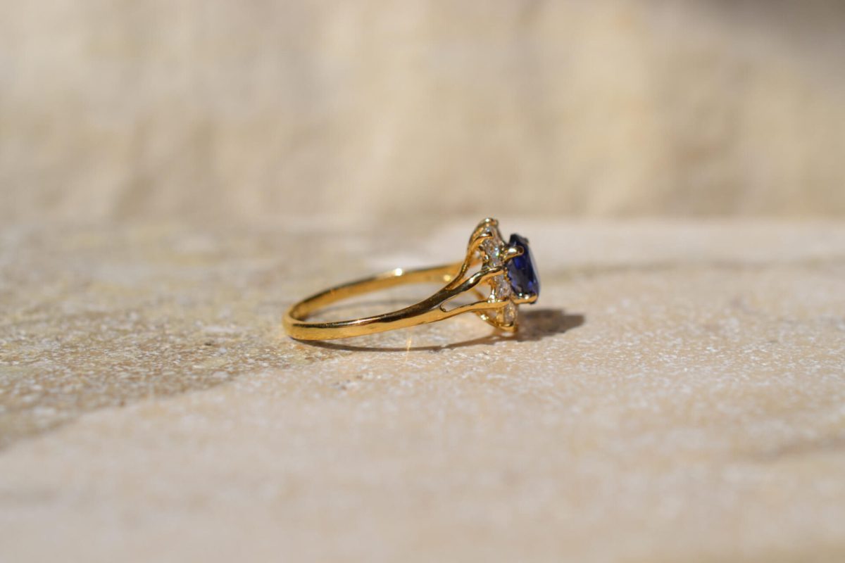 Bague ancienne en Or jaune 18 carats centrée d'un Saphir entouré d'Oxydes