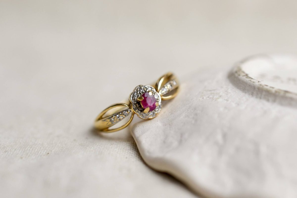 bague en or jaune surmontee d un rubis de taille ovale dans un entourage de petits diamants - bague ancienne