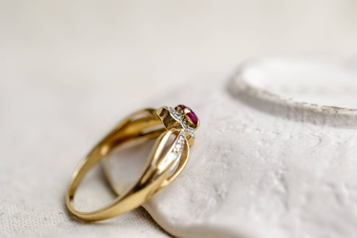 bague en or jaune surmontee d un rubis de taille ovale dans un entourage de petits diamants - bague de femme