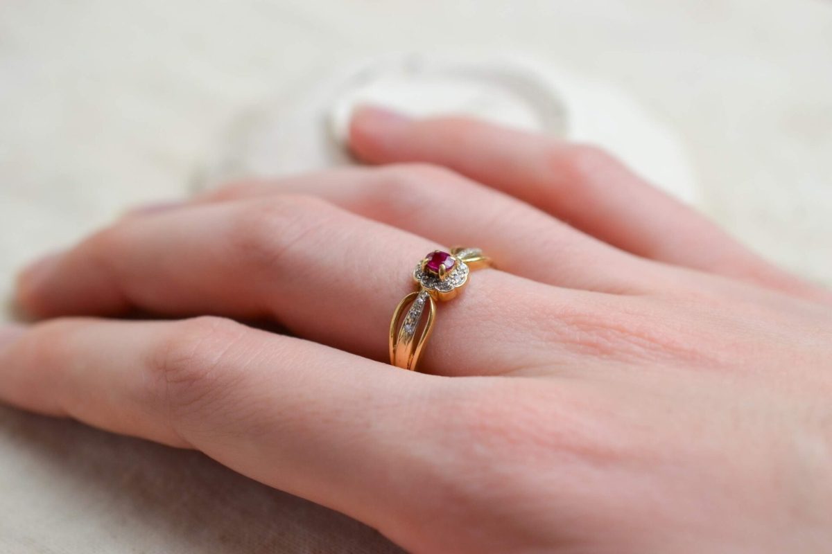 bague en or jaune surmontee d un rubis de taille ovale dans un entourage de petits diamants - bague elegante
