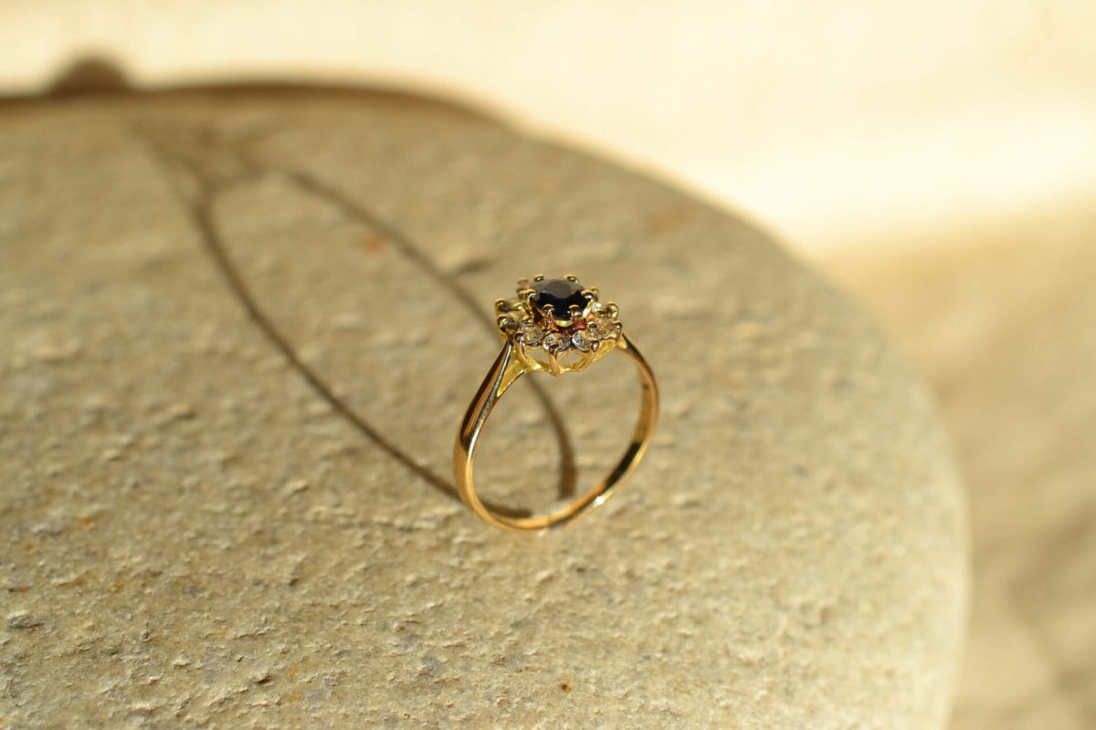bague marguerite en or jaune sertie d un saphir dans un entourage d oxydes - bague de seconde main