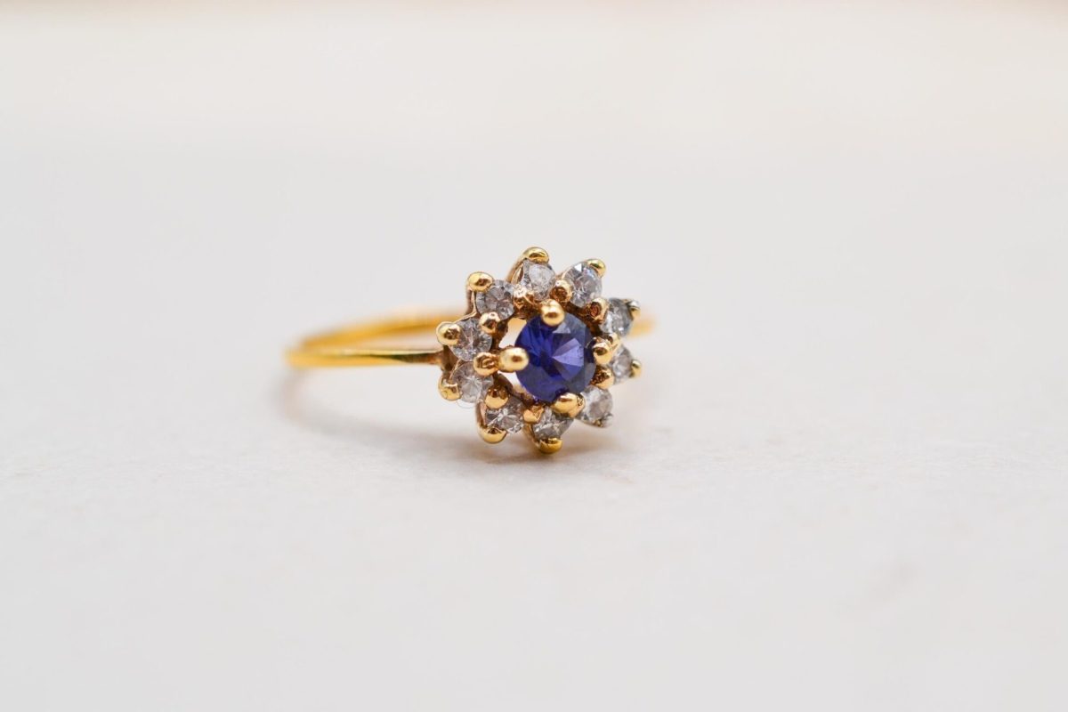 bague marguerite en or jaune centree d un saphir de synthese dans un entourage d oxydes - bague ancienne