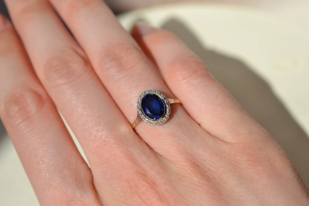 bague en or jaune ornee d un saphir verneuil dans un entourage en platine serti de diamants - bague femme